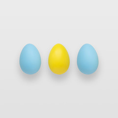 Blue and yellow easter eggs on a gradient gray background.