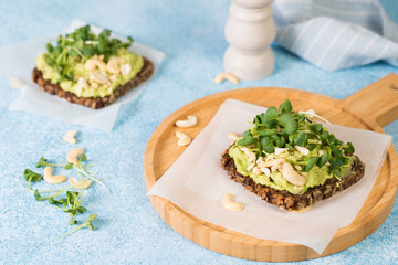 Vegan green toast with avocado paste , nuts and microgreens