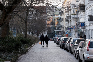 Kontaktverbot, mehr als zwei Peronen dürfen sich nicht mehr zusammenfinden - Paar läuft über die leere Lettestrasse in Berlin-Prenzlauer Berg
