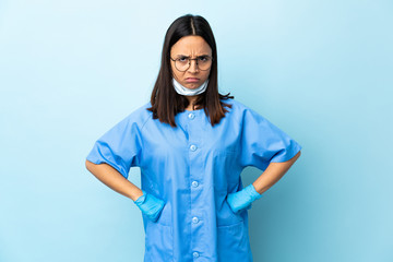 Surgeon woman over isolated blue background angry