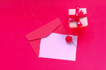Close up gift box and envelope on red background 