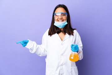 Scientist woman investigating a vaccine to cure coronavirus disease surprised and pointing side