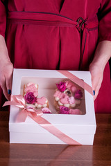 The hands of the confectioner with a delicate and delicious cake of letters.