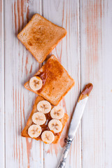 Two delicious toasts with salted caramel and bananas on the table.