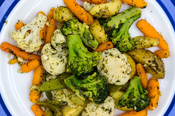 Fried vegetables on a plate. Broccoli, potatoes, cauliflower, green okra beans, carrots. Vegetarian food.