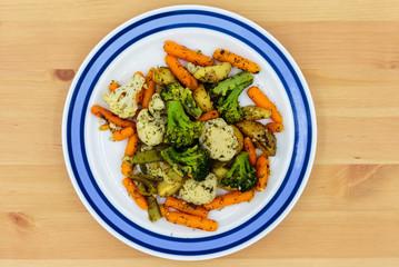 Fried vegetables on a plate. Broccoli, potatoes, cauliflower, green okra beans, carrots. Vegetarian food.