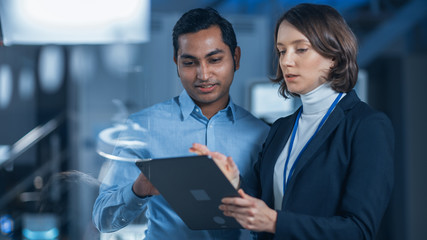 In Technology Research Facility: Female Project Manager Talks With Chief Engineer, they Consult...