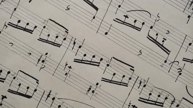 camera movement along a musical notepad, close up, macro view, slider moving