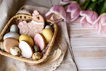 Beautiful Easter composition of eggs with natural colors, gingerbread, flowers, feathers.