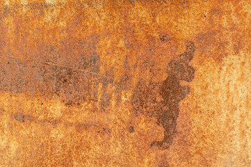 Old rusty metal wall with traces of paint.