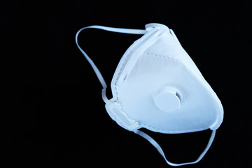 White ffp3 face mask with a valve on a black background
