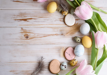 Beautiful Easter composition of eggs with natural colors, gingerbread, flowers, feathers.