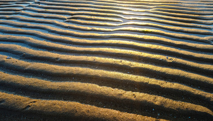 Texture of water and sand in the form of a wave in a sunset