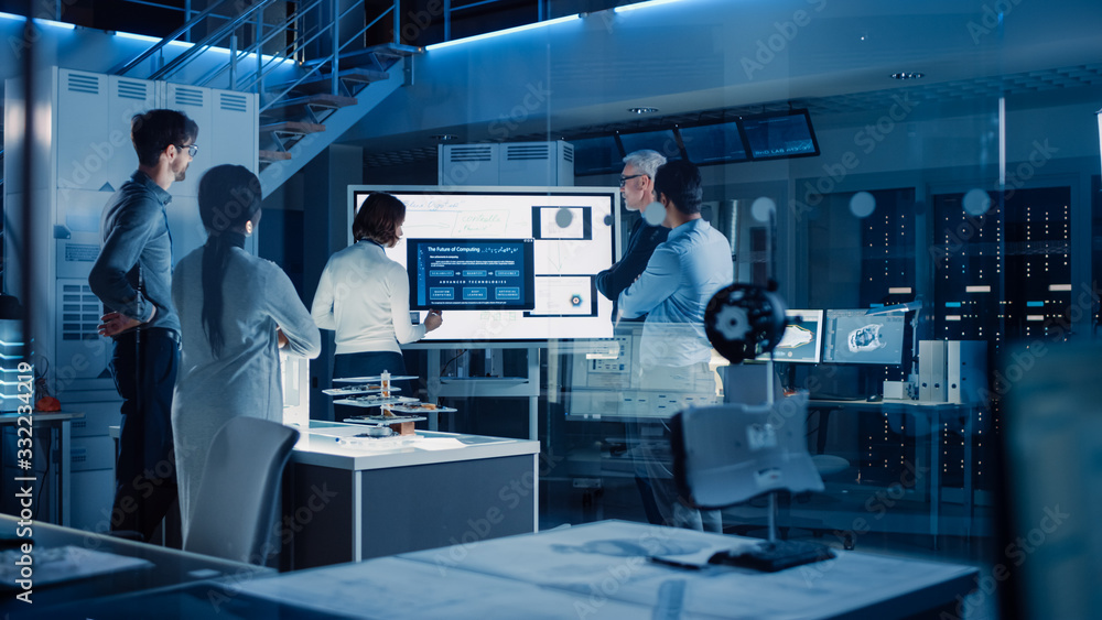Poster Engineers Meeting in Research Laboratory: Female Engineer Leads Presentation Using Vertical Digital Whiteboard, Shows Machine Blueprint, Data Analytics and Neural Network while Colleagues Listening