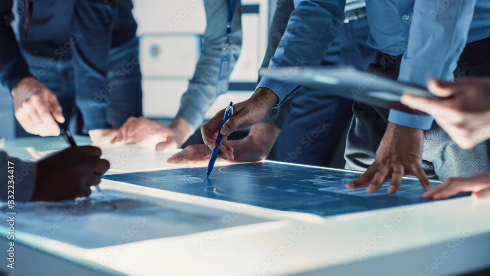 Aufkleber engineer, scientists and developers gathered around illuminated conference table in technology resea