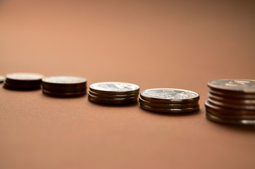 small stacks of coins on a brown background