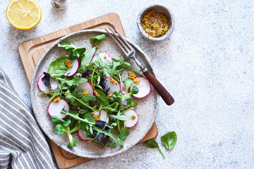 Mix salad with radish and mustard sauce. Salad on the kitchen table. View from above.