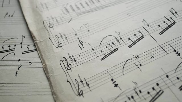 camera movement along a musical notepad, close up, macro view, slider moving