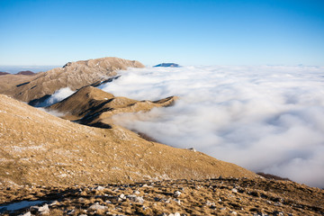 Mountain peaks emerging through the low cloud cover on sunny day in winter in Matese Park