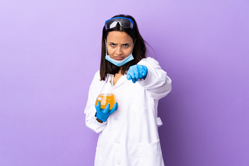 Scientist woman investigating a vaccine to cure coronavirus disease with fighting gesture
