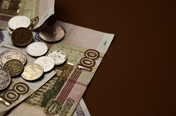 bills and coins rubles collapse on a brown background with copy space
