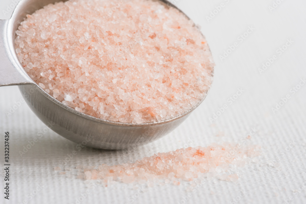 Wall mural pink himalayan salt spilled from a teaspoon