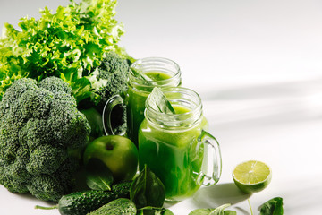 Fresh blended green smoothie in  jar on white table. Detox and diet  concept. Vegetarian food.