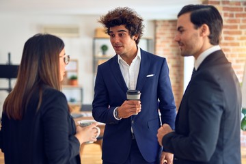 Young beautiful group of business workers smiling happy and confident, Standing with smile on face drinking coffee and speaking at the office
