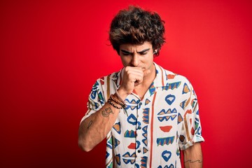 Young handsome man on vacation wearing summer shirt over isolated red background feeling unwell and coughing as symptom for cold or bronchitis. Health care concept.