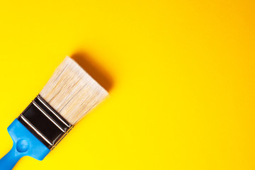 Paint brush close-up on a yellow background, copy paste, left orientation.