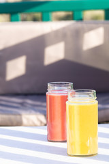 Yellow Banana, pear and red apple, raspberry smoothie. Glass, jar. Restaurant, table, armchair. Outside. Health, vegetarian, vegan breakfast, drink. No plastic, Ecology. copy space. vertical. 