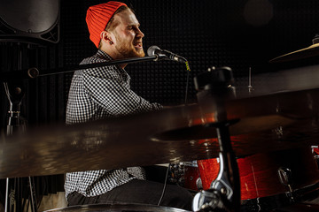 professional caucasian musician play on drums and sing his favourite song in studio, talented music performer enjoy his hobby. music concept