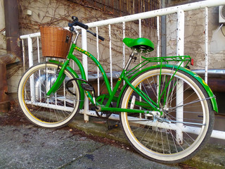 Fototapeta na wymiar Old retro green bike at european city. Side view of bicycle.