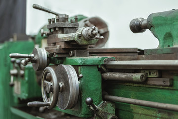 The old lathe is painted green. A small workshop for metal processing. Selective focus