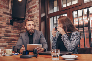 Business people are using digital tablet, talking, drinking coffee in cafe