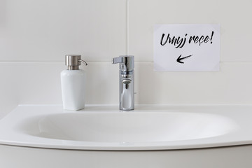 Sink with soap dispenser and note saying 