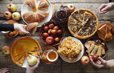 Feast, Easter food, treats with Easter cakes and colored eggs.Hands of people eating food at the table.