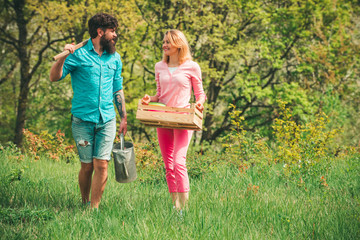 Fototapeta premium Gardening in spring - happy couple harvesting and having lots of fun. I like spending time on farm. Cheerful couple of farmers standing in vegetable garden.