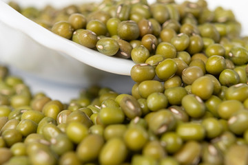 Green mung bean in a white ceramic bowl. Macro shot. Cooking traditional dishes