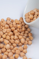 Turkish peas beans and a white cup on a white table close-up. Macro shot. Vertical view