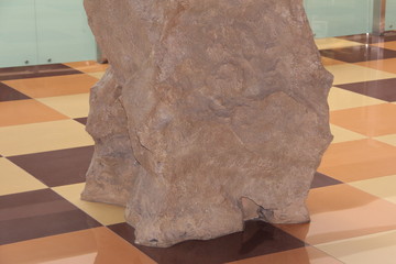 Obraz na płótnie Canvas A large beige stone. Imitation of a stone in the room.