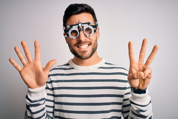 Naklejka premium Young handsome man with beard wearing optometry glasses over isolated white background showing and pointing up with fingers number eight while smiling confident and happy.