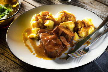 Braised pork neck in own sauce served with boiled potatoes.