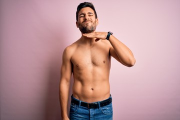 Young handsome strong man with beard shirtless standing over isolated pink background cutting throat with hand as knife, threaten aggression with furious violence