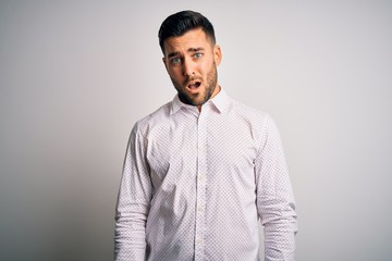 Young handsome man wearing elegant shirt standing over isolated white background In shock face, looking skeptical and sarcastic, surprised with open mouth