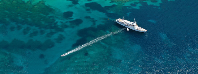 Aerial drone top down photo of luxury yacht with wooden deck anchored in open ocean sea © aerial-drone