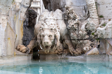 Fototapeta na wymiar Detail of lion statue at famous Fountain of the Four Rivers. Navona Square in Rome. Italy. 