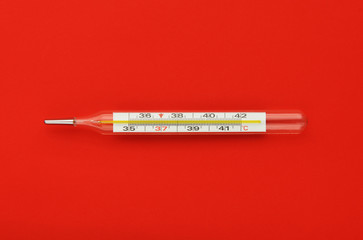 Thermometer on a red background.Flu epidemic, coronavirus. Temperature 37.2 C.