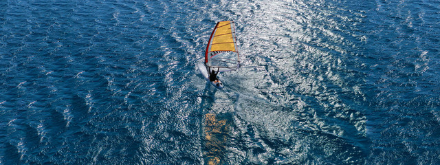 Aerial drone ultra wide photo of wind surfer cruising in high speed in tropical exotic bay © aerial-drone