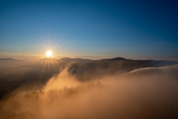 Sunrise in the mountains in spring with a roller with fog in the valley, morning in Czech Beskydy